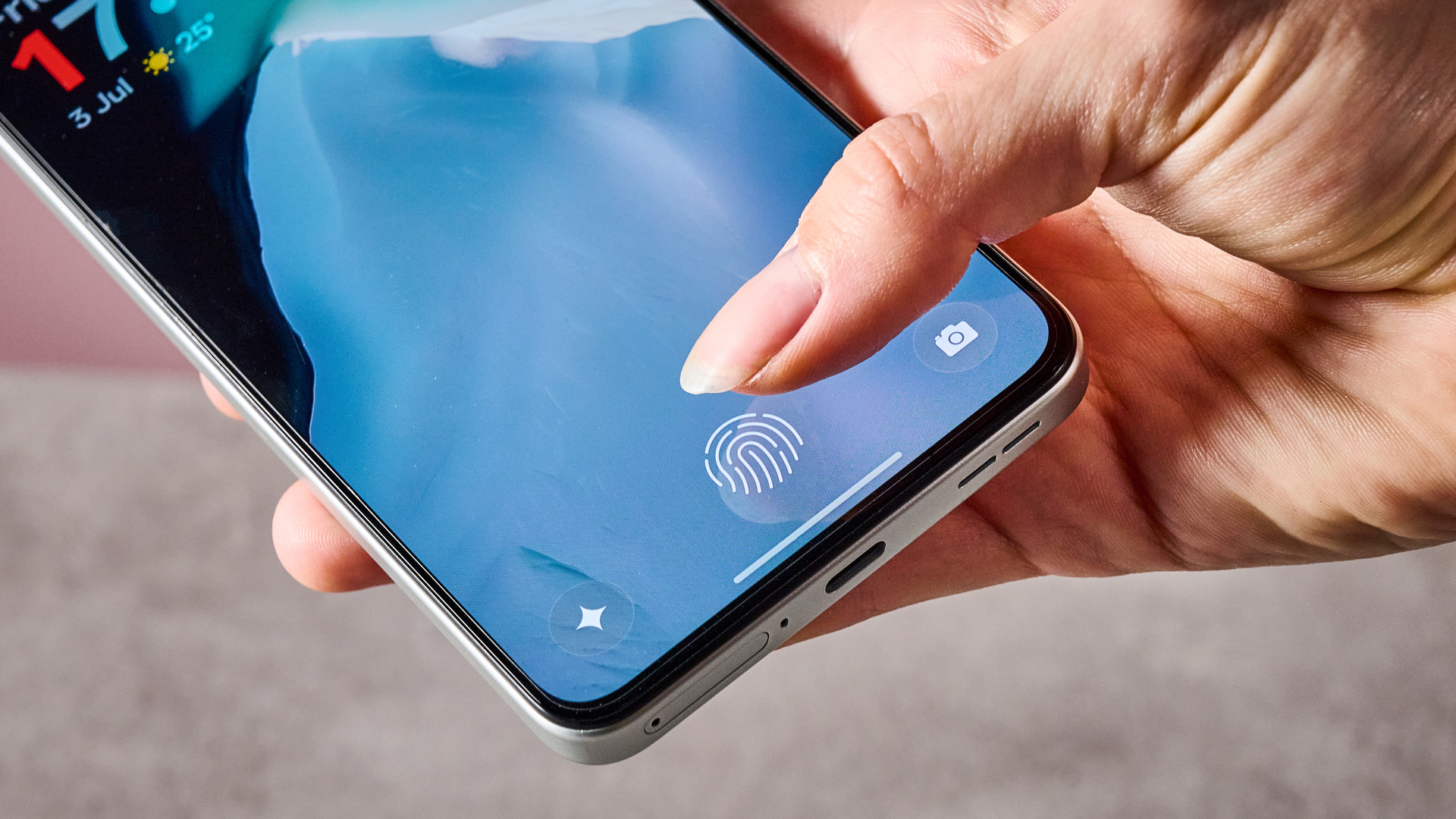 A woman's thumb hovering over the fingerprint scanner on the OnePlus Nord CE5.
