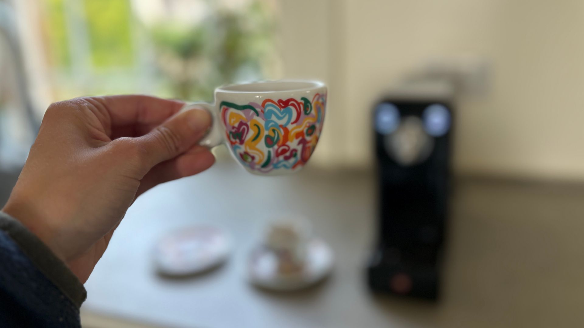 Holding an espresso in the illy cup made in the illy X3 coffee machine