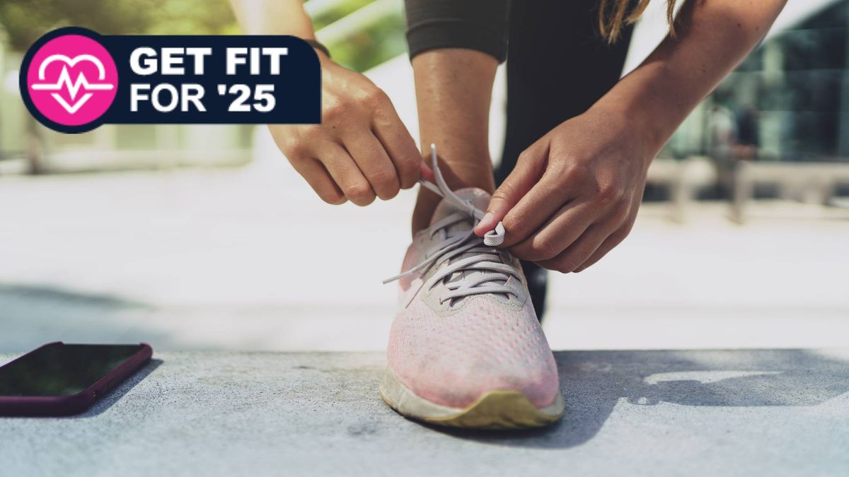 Woman lacing up trainers/sneakers to go running on sunny day