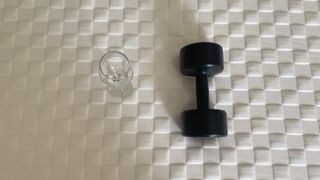 Levitex Gravity Defying Mattress review image shows a black test weight placed next to a wine glass during a motion isolation test