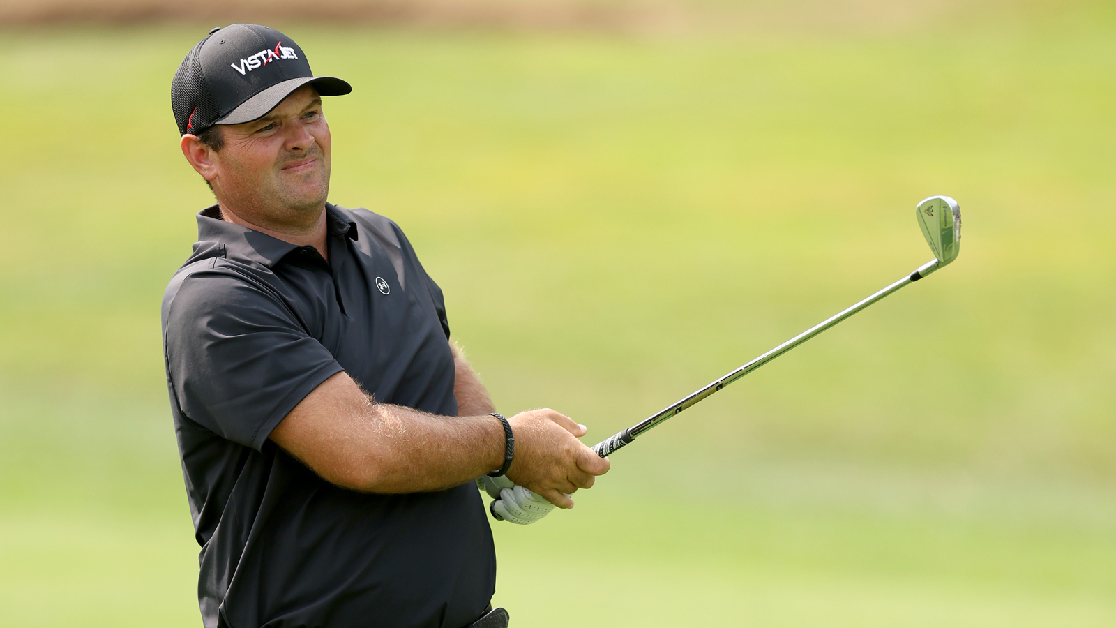 Patrick Reed watches a shot into the green
