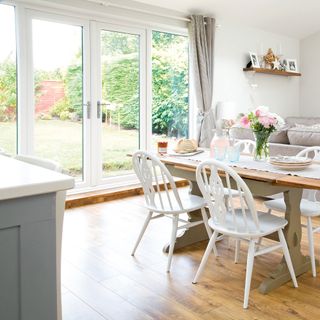 Open plan dining-living space with wooden floors and white walls