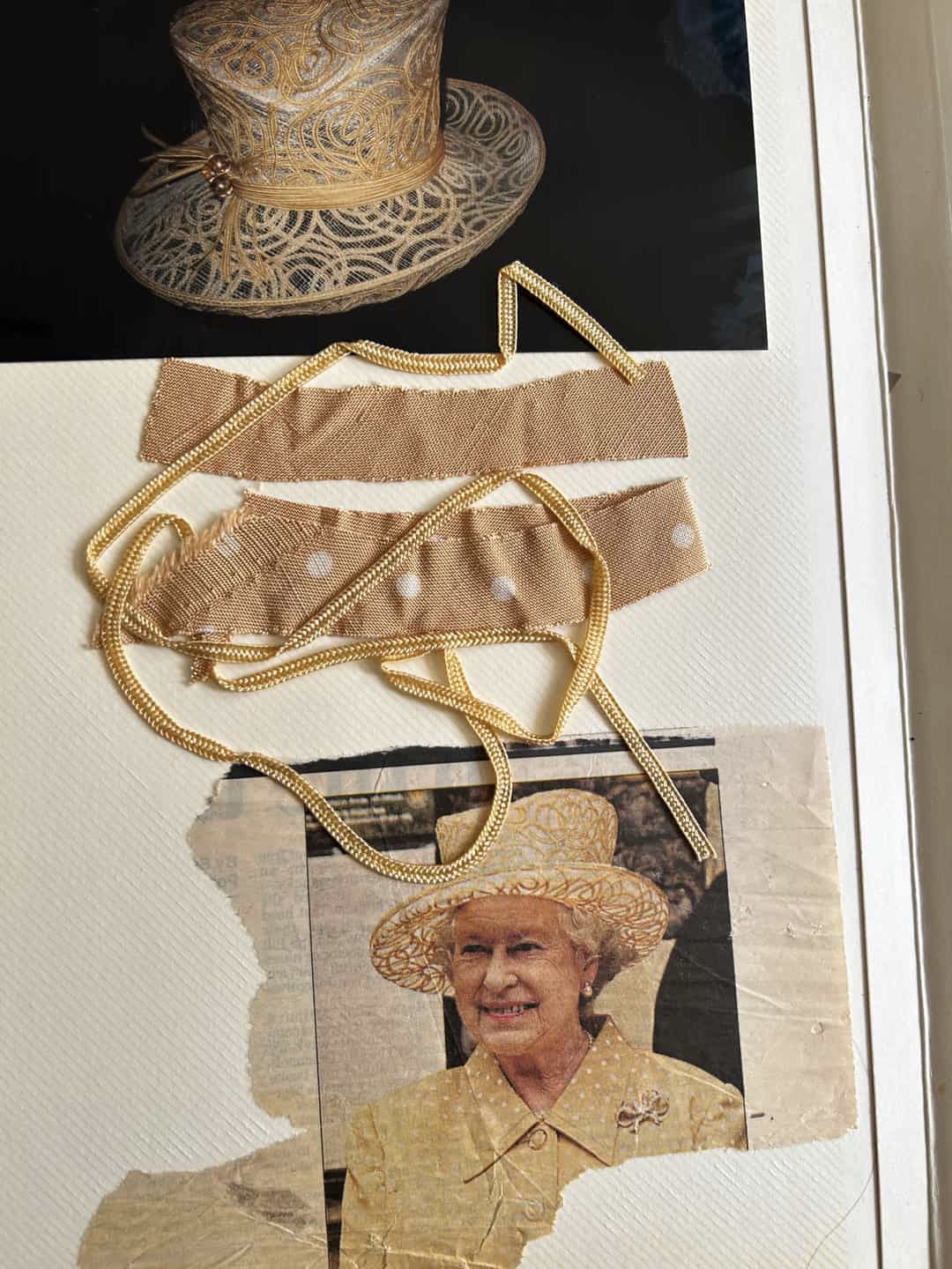 A scrapbook with fabric swatches, a photo of Queen Elizabeth and a picture of a gold hat