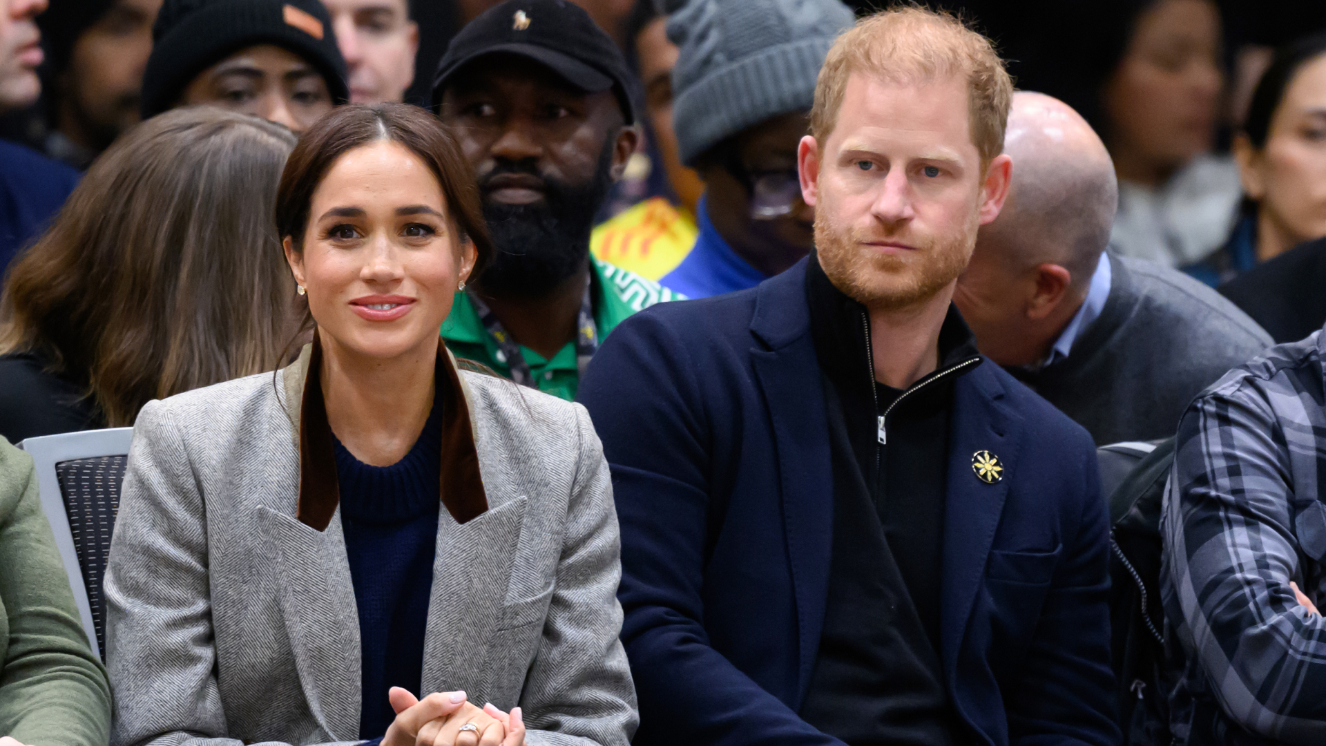 Meghan Markle and Prince Harry sitting in the audience at Invictus Games wearing blazers