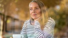 woman looking contemplative drinking from a mug