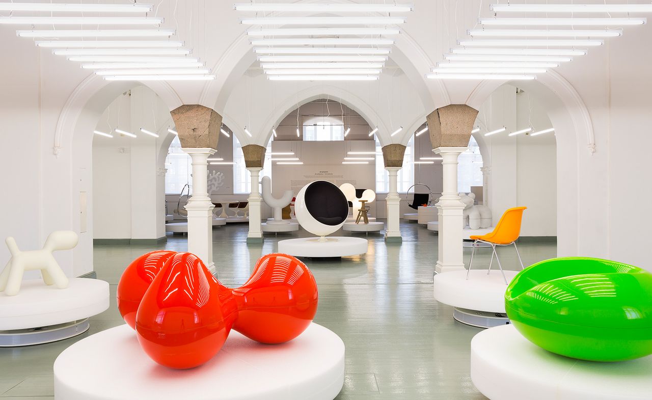 Museum featuring white walls and ceiling with grey flooring. Multiple items display all over the museum space on white circular podiums