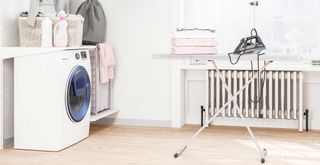 white laundry room with ironing board as a good laundry room organization idea