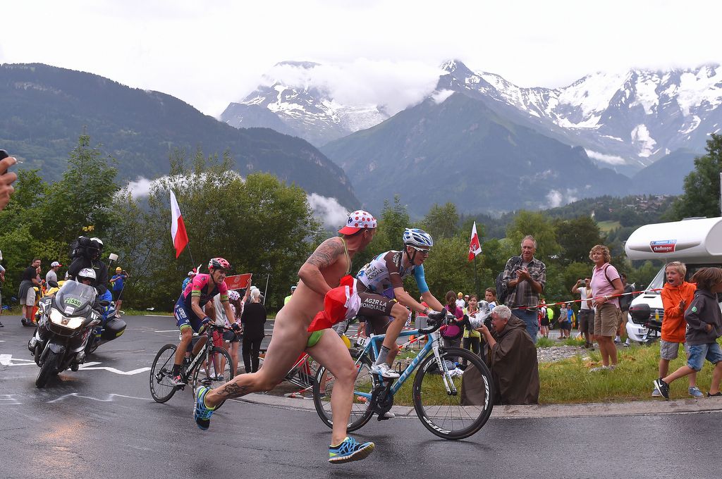 A Borat impersonator runs alongside Romain Bardet on the climb to Saint-Gervais