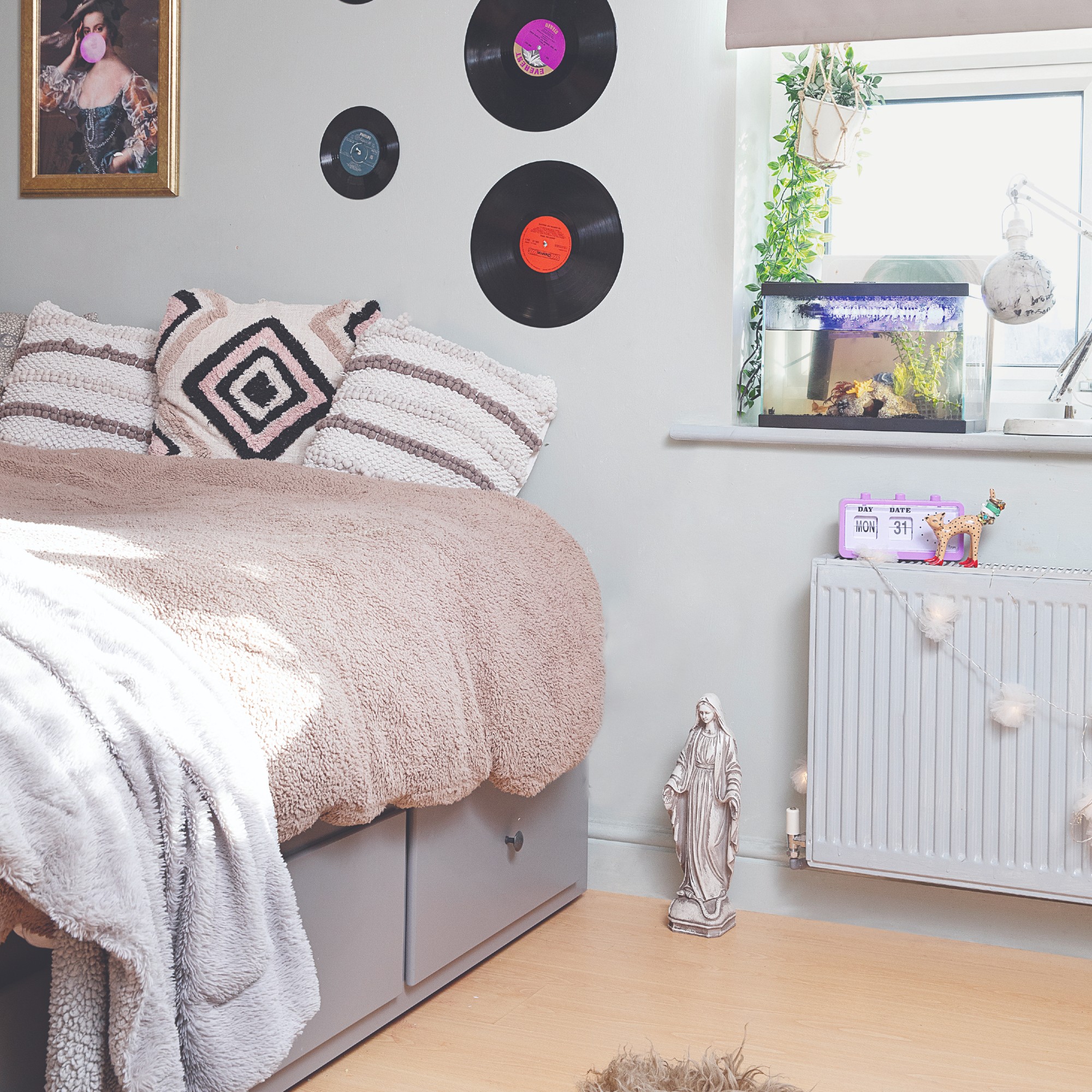 A teenage girl's bedroom with a storage bed and vinyls used as wall decor