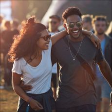 Stock photo of young happy couple laughing at outdoor music festival 