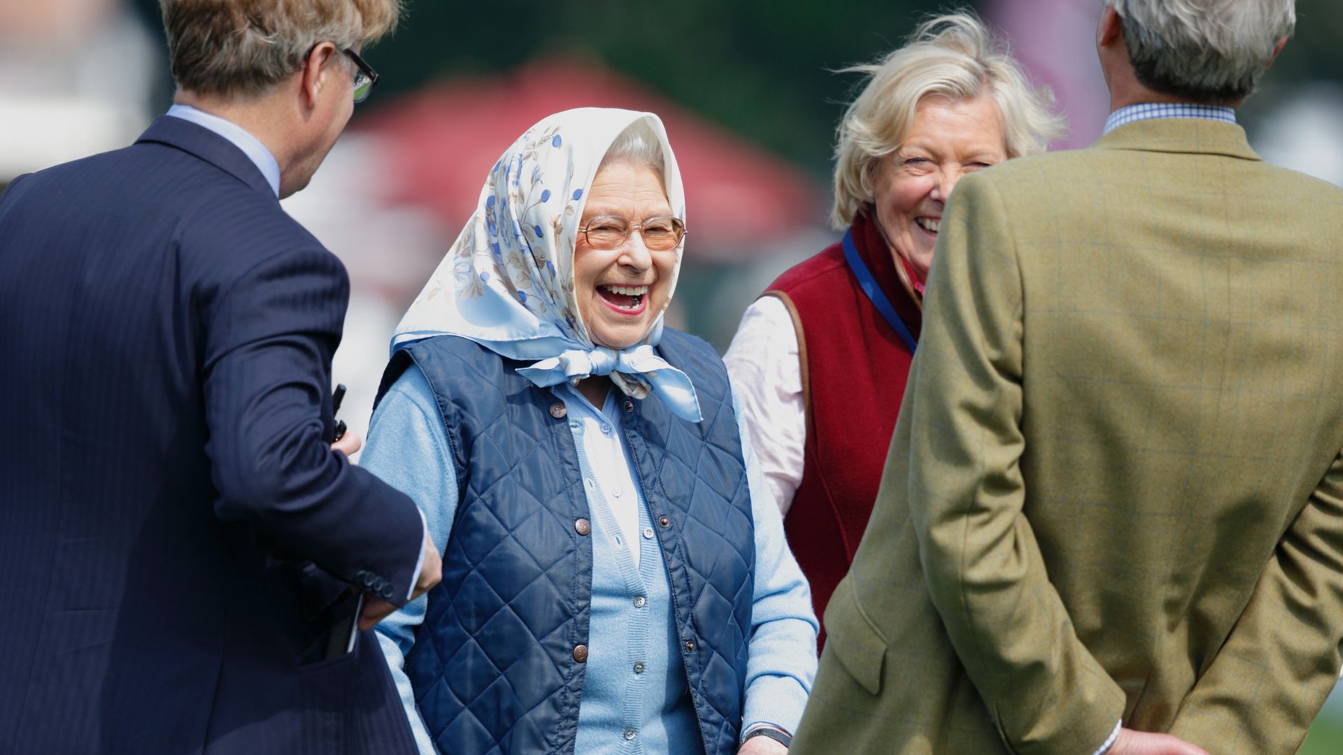 Queen Elizabeth II laughs with guests during the Royal Windsor Horse Show in Home Park on May 12, 2016 in Windsor, England