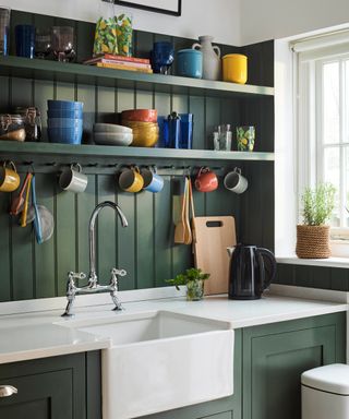 Panelled green kitchen with open shelving