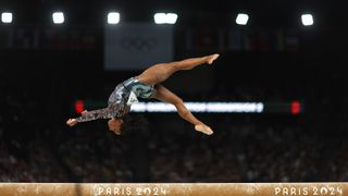 Simone Biles flips on the balance beam.