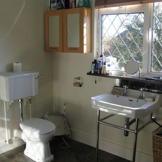 bathroom with white basin commode and bathroom cabinet