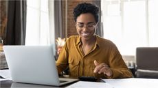 A woman works on her 401(k) allocation on a computer.