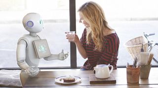 Image of Pepper robot and woman sitting at a table