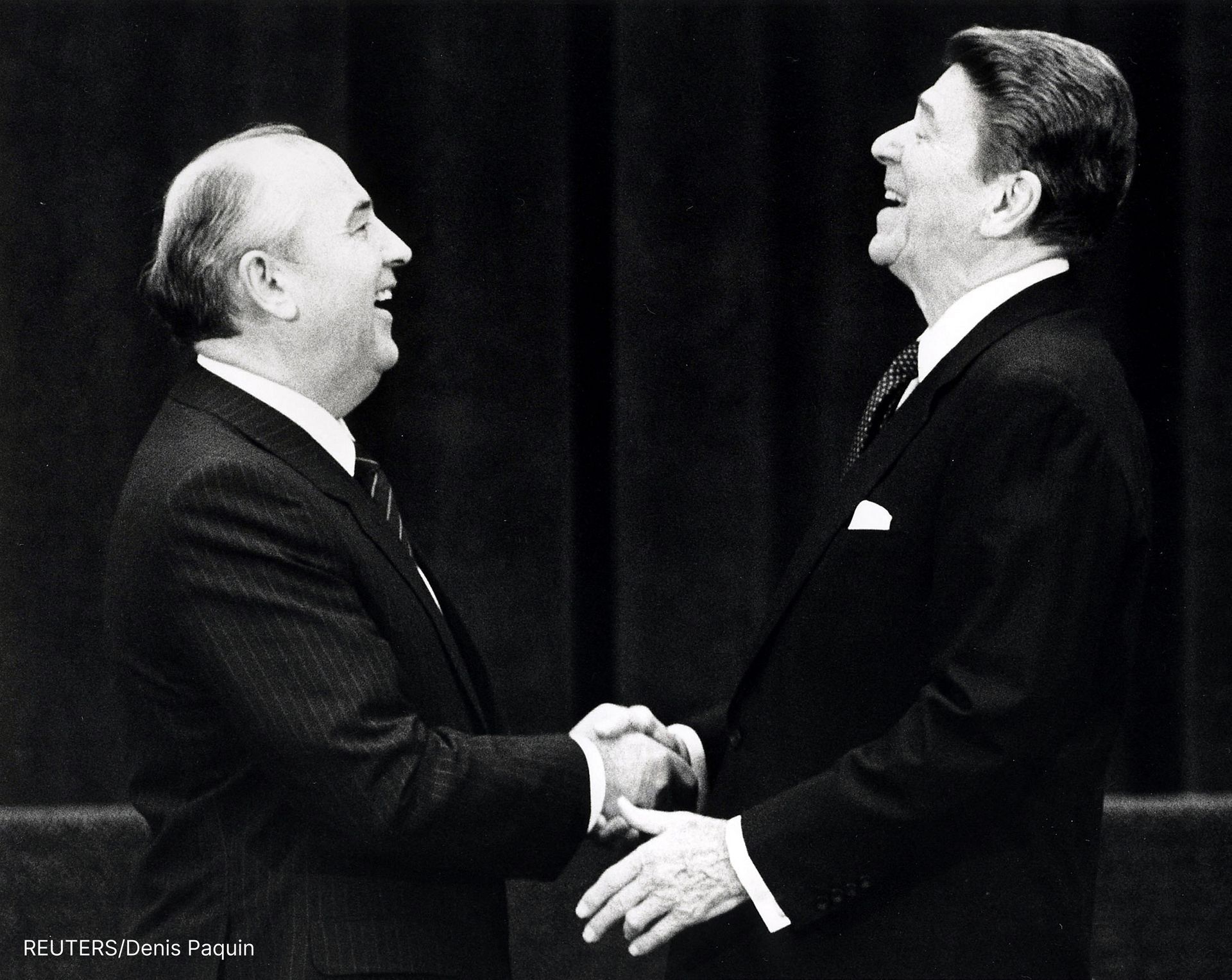 Gorbachev and Reagan shake hands, laughing
