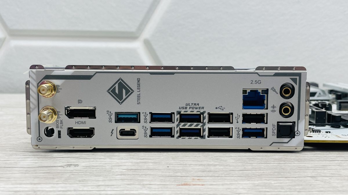 An ASRock B860 Steel Legend Wi-Fi motherboard on a desk with SSD covers removed.