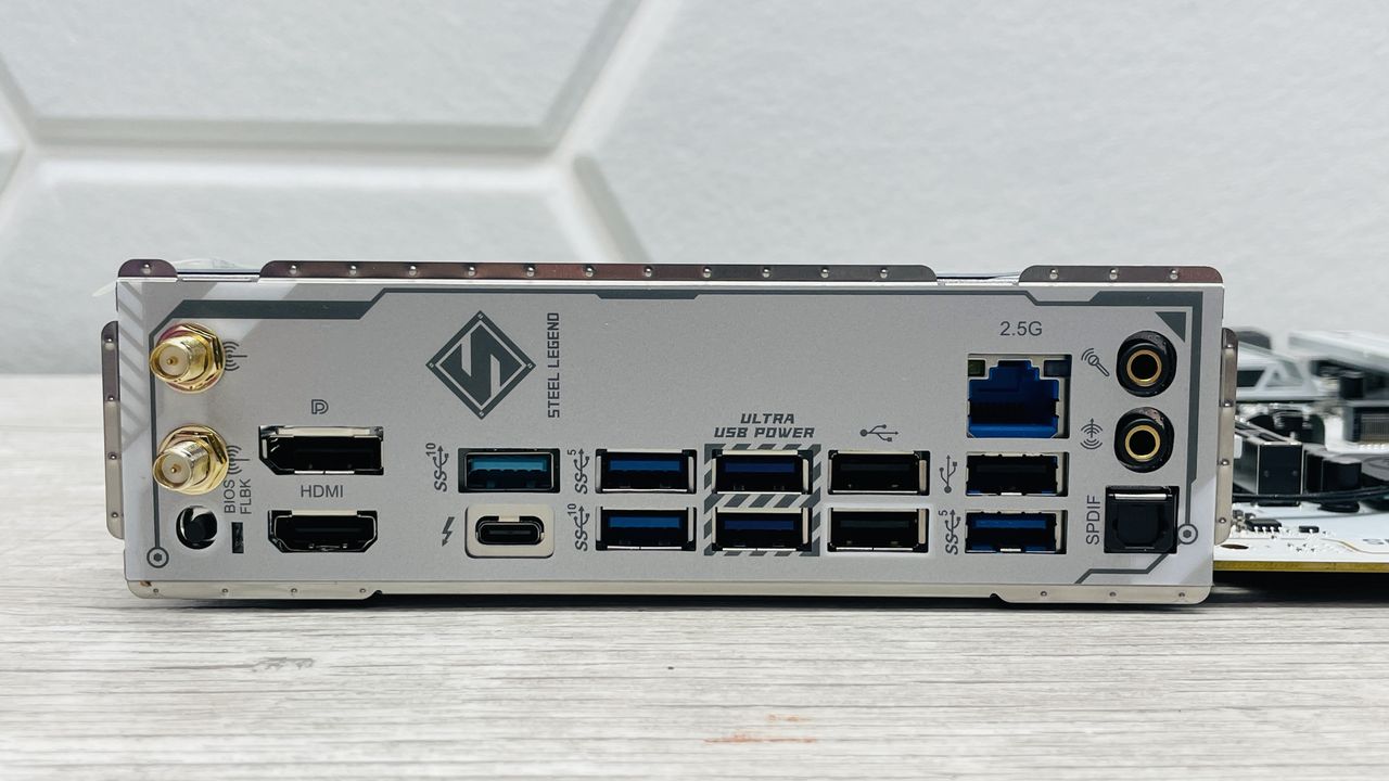 An ASRock B860 Steel Legend Wi-Fi motherboard on a desk with SSD covers removed.