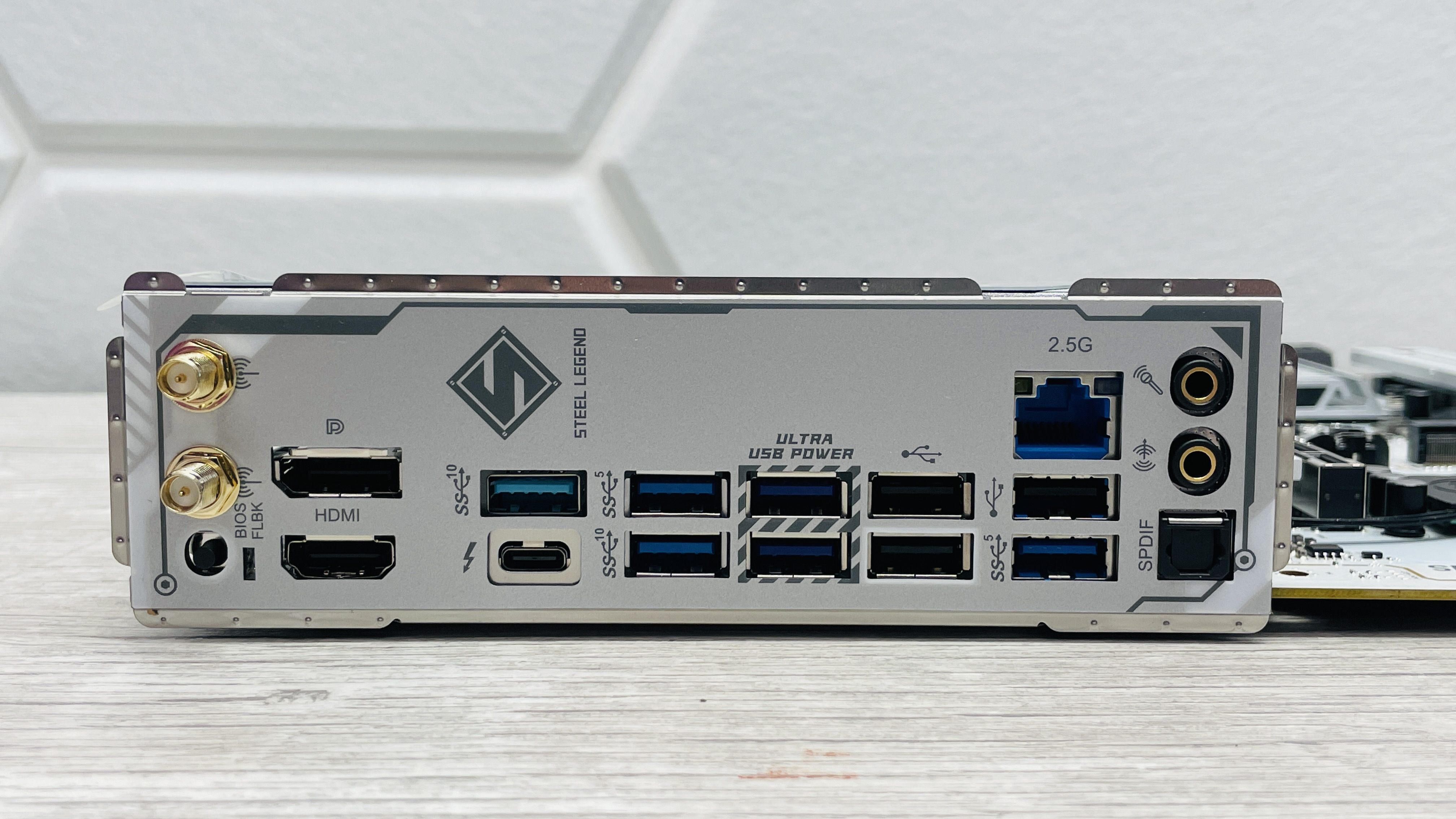 An ASRock B860 Steel Legend Wi-Fi motherboard on a desk with SSD covers removed.