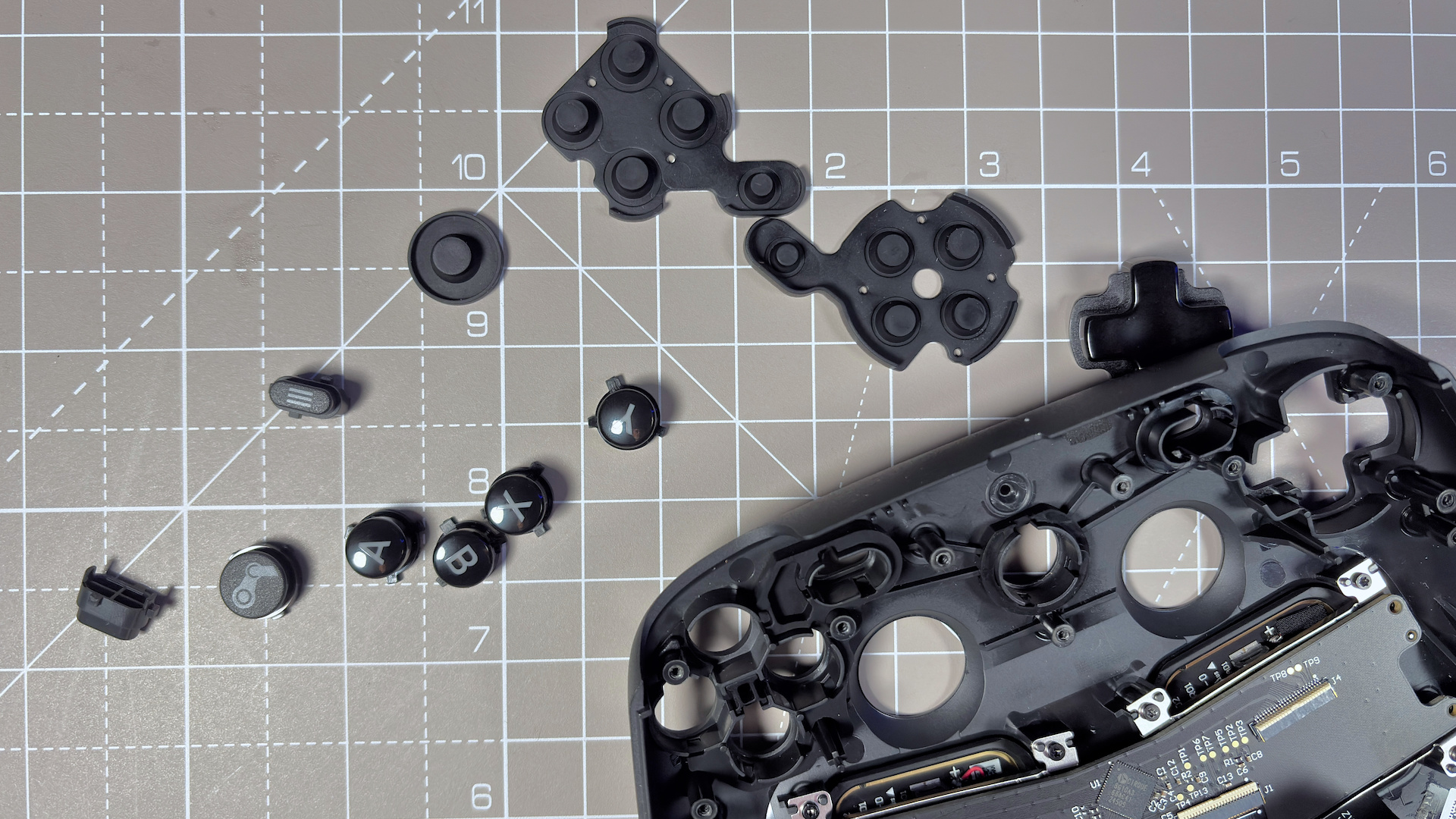 The Steam Controller on a desk during a teardown, with various parts removed.