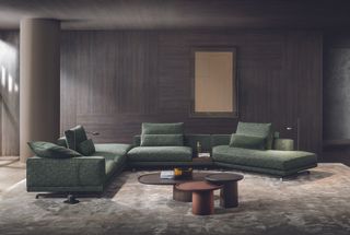 Green lounge suite in front of wall cladded with wooden panels