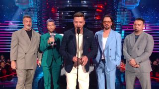 Justin Timberlake speaking into microphone during NSYNC reunion at MTV VMAs