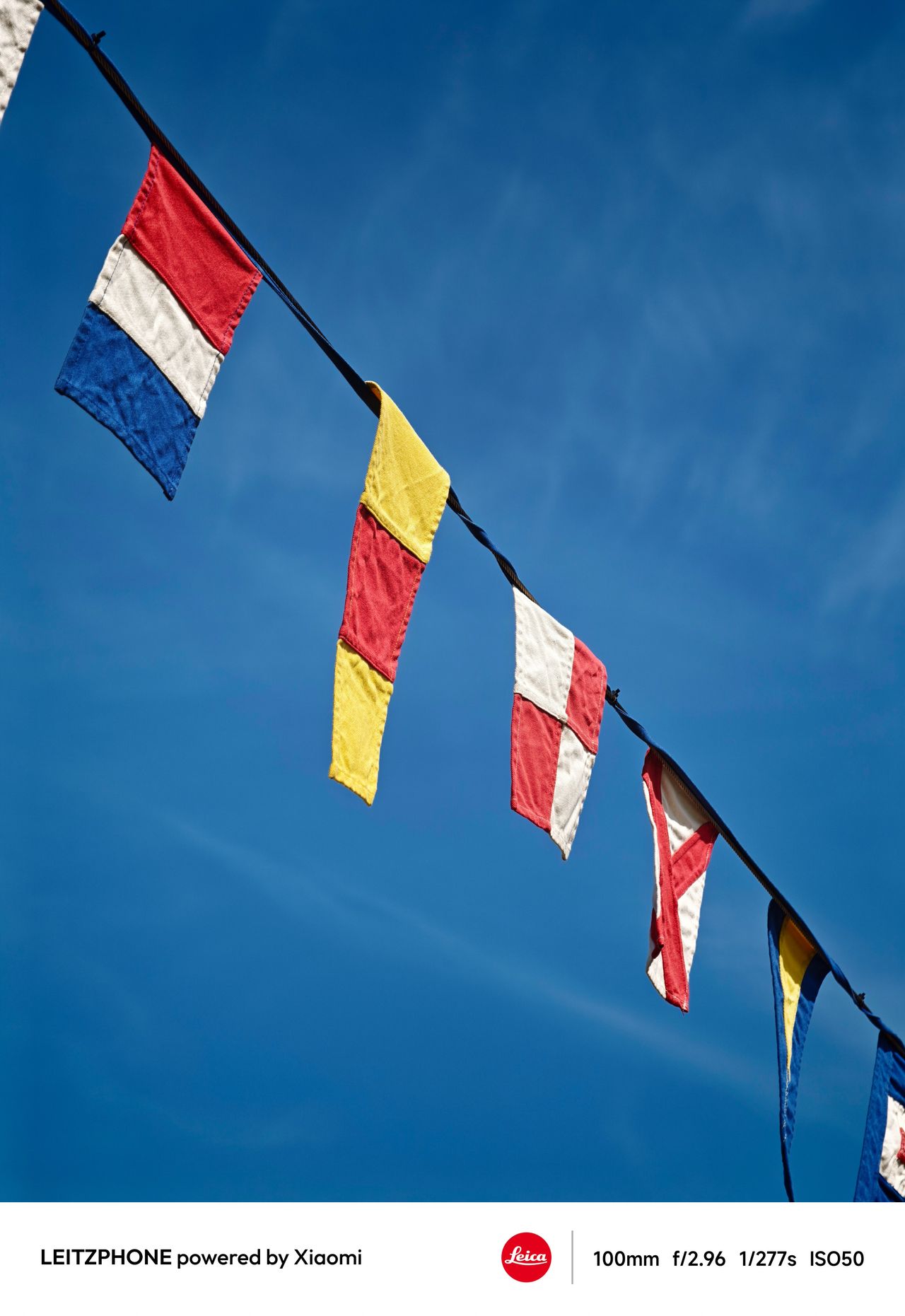 Colorful signal flags hanging against a blue sky