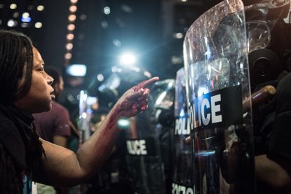 A protester stands before police officers in Charlotte, North Carolina