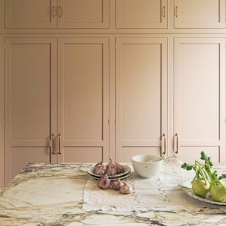 full-height pink cabinetry with a close-up of the island with marble worktop