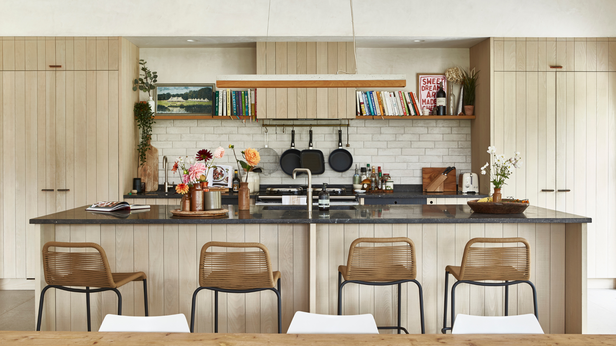 Beige kitchen with island, cookbokokes and decor.
