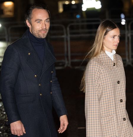 James Middleton wearing a blue coat next to Alizee Thevenet in a plaid suit