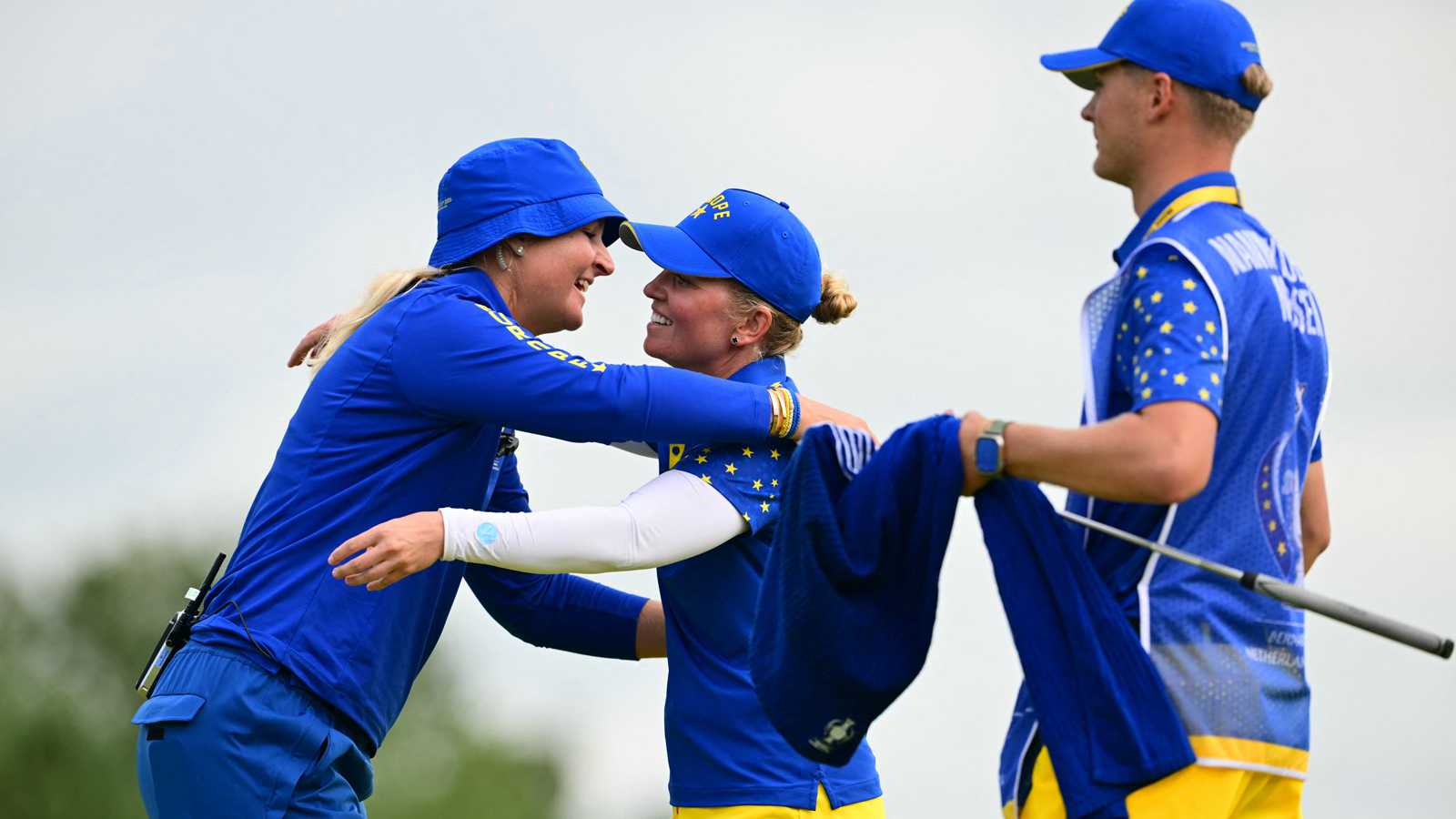 Golfers hug on the 18th green