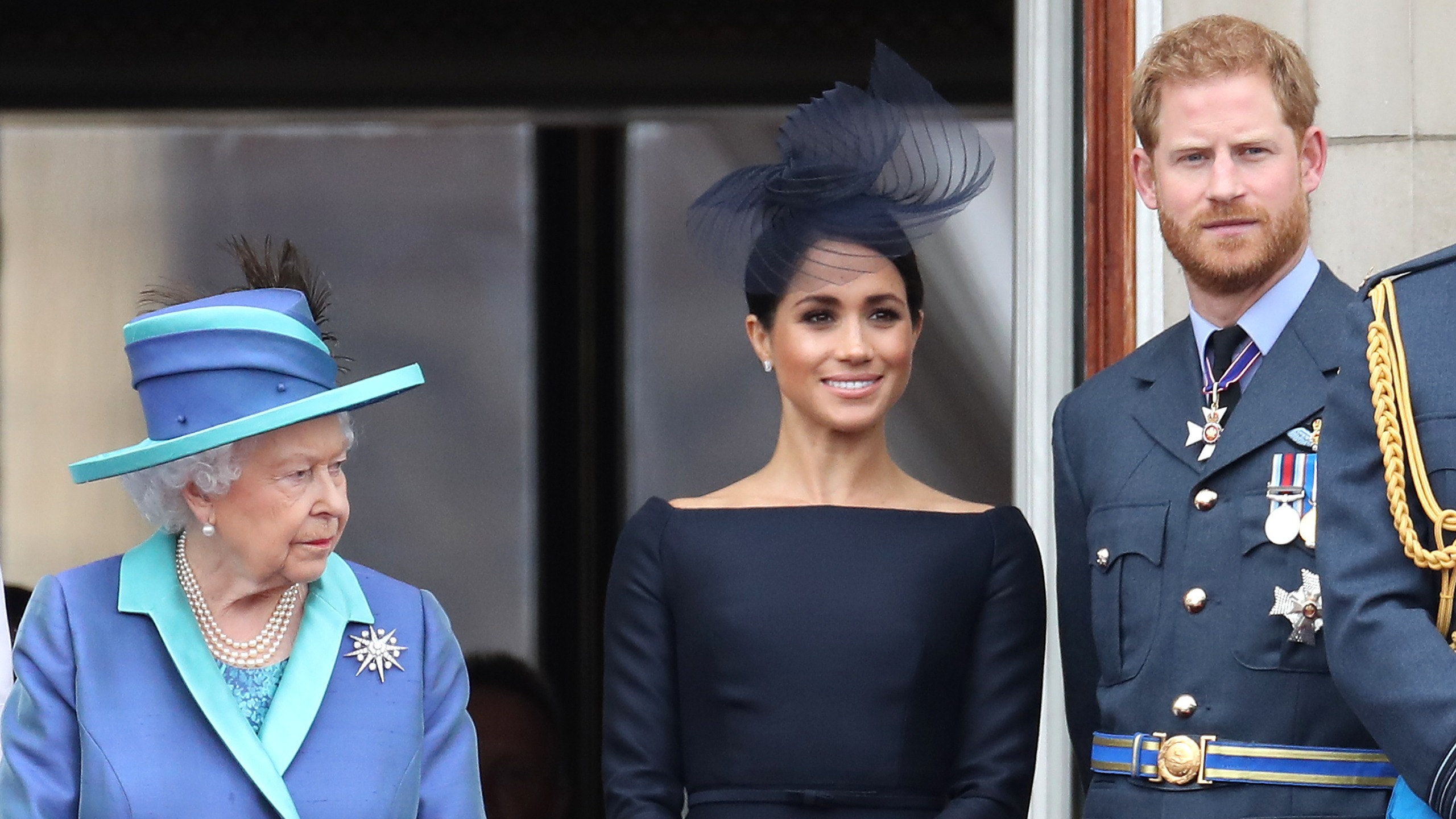 Queen Elizabeth II, Prince Harry and Meghan, Duchess of Sussex on the balcony of Buckingham Palace as the Royal family attend events to mark the Centenary of the RAF on July 10, 2018