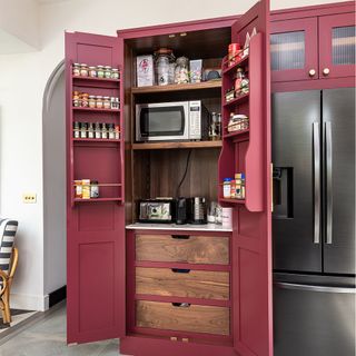 Red shaker kitchen with built-in pantry.