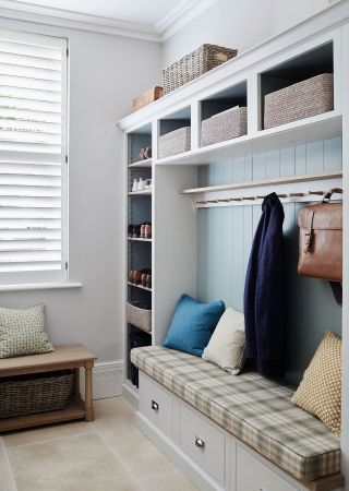 An example of mudroom ideas showing a tartan bench with cushions and coat hooks above