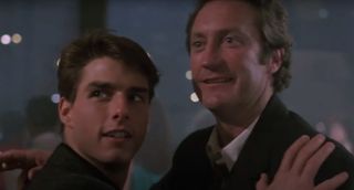 Tom Cruise stands hugging Bryan Brown in a club atmosphere in Cocktail.