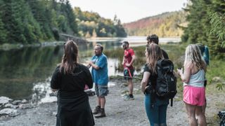 Group of hikers stop near a picturesque lake