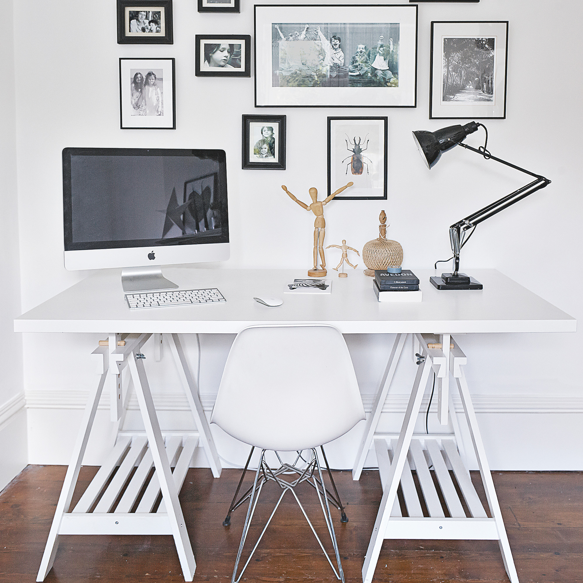White home office with compuetr on desk and a gallery wall behind