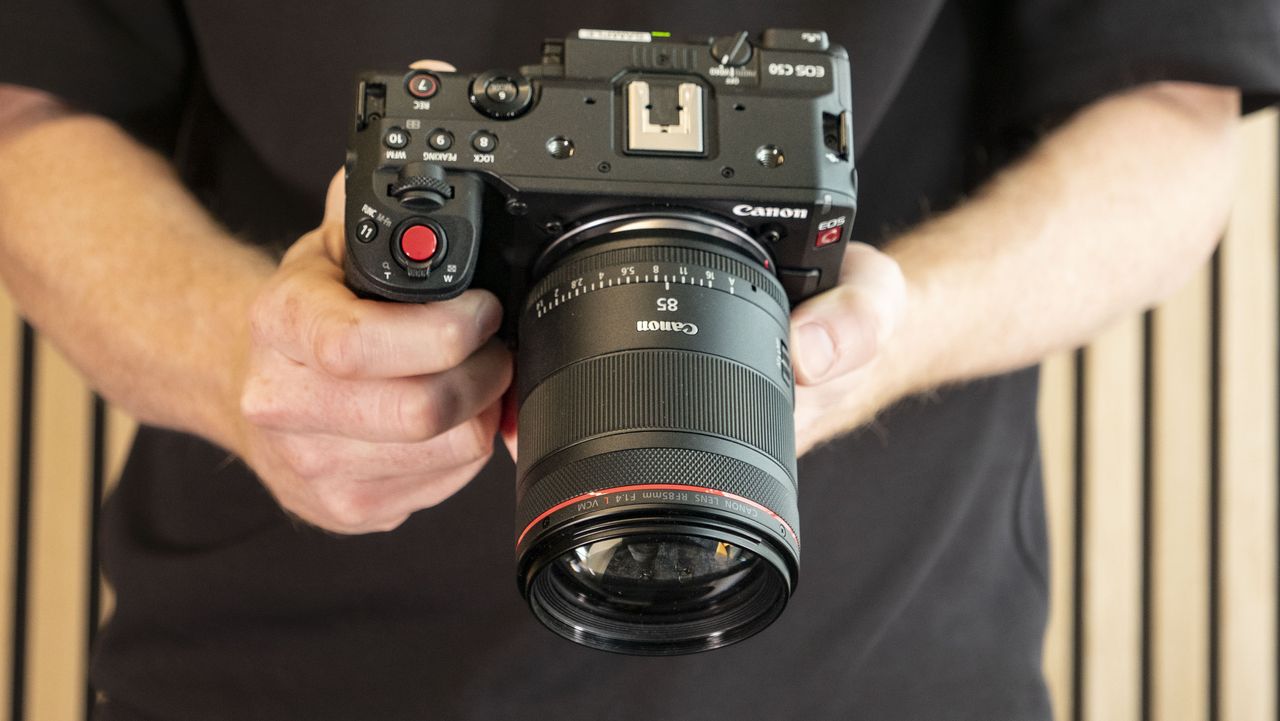 Canon RF 85mm F1.4L VCM lens attached to the Canon EOS C50 camera, in photographer's hands
