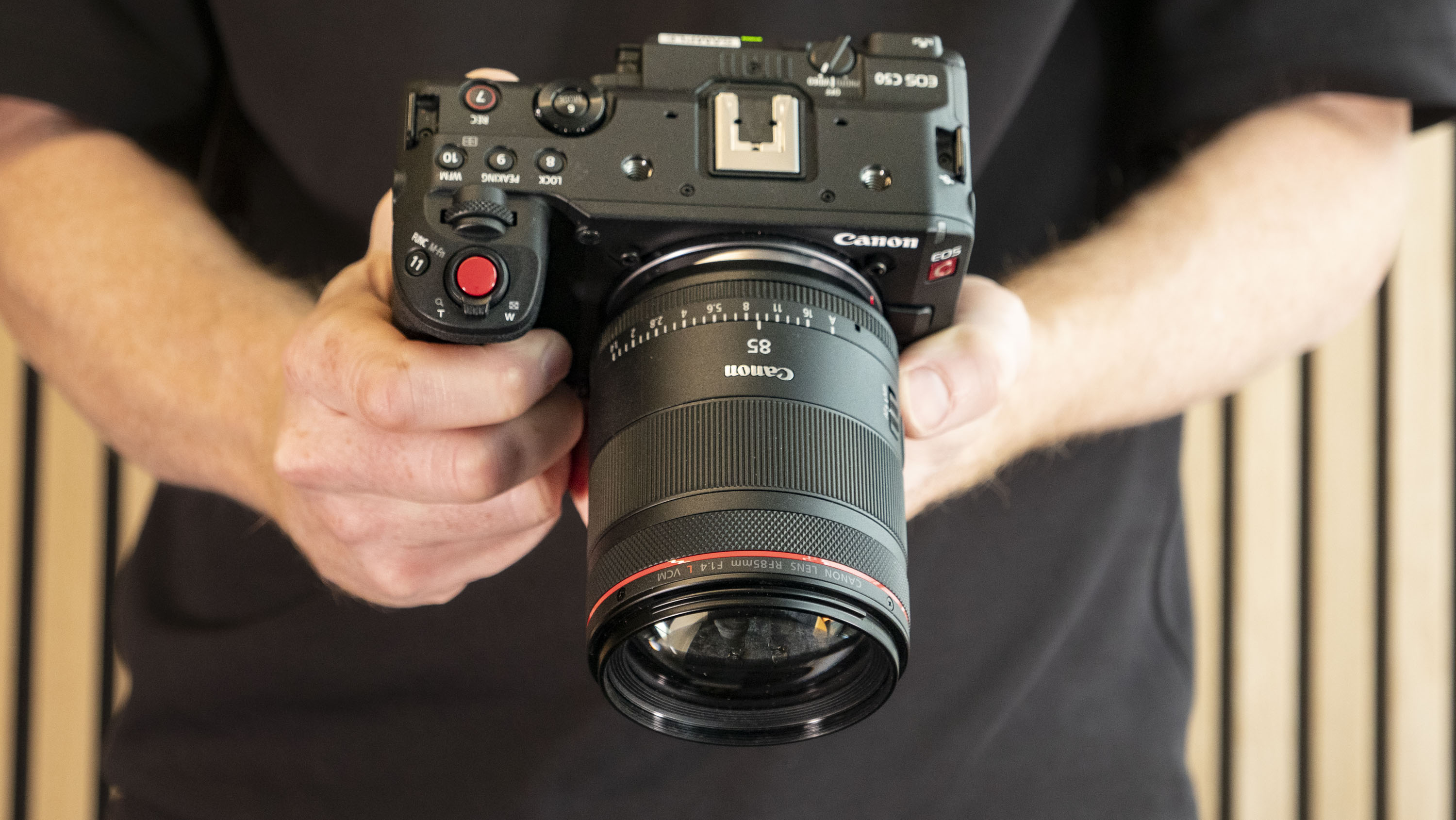 Canon RF 85mm F1.4L VCM lens attached to the Canon EOS C50 camera, in photographer's hands