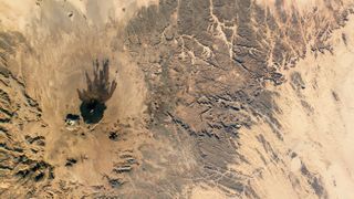 A mountain range and canyons in the Sahara desert seen from space