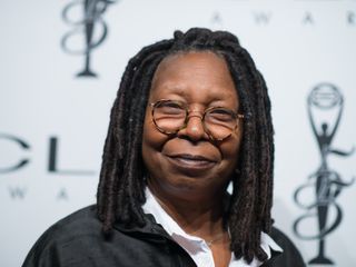 Whoopi Goldberg poses on the red carpet for cameras