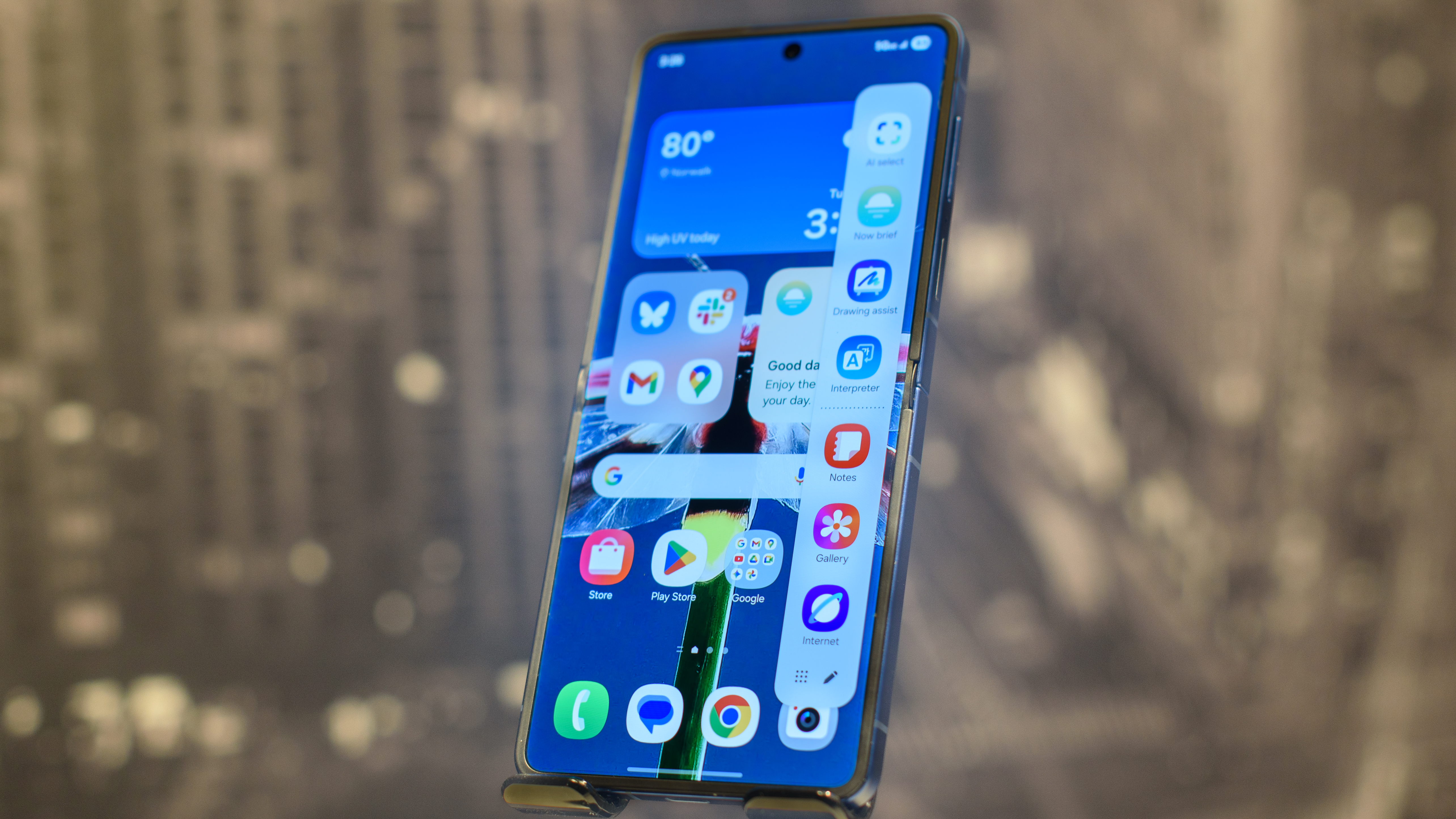 Samsung Galaxy Z Flip 7 in blue at a 3/4 angle showing a home screen panel with the Edge Panels on screen