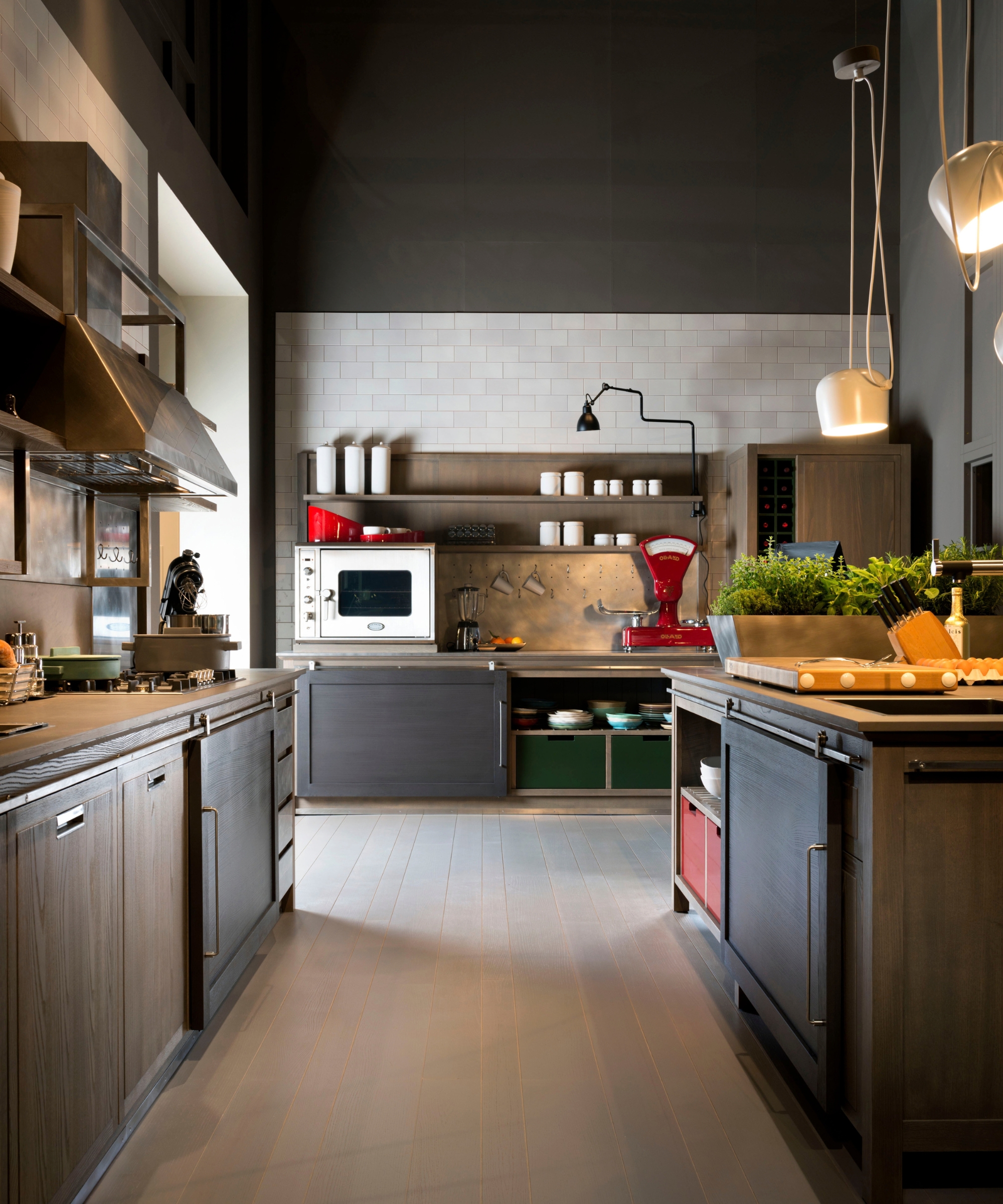Industrial-style galley kitchen with dark cabinetry, open shelving, subway tile, and a vintage red scale.