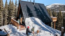 exterior of mountain chalet with snow and trees
