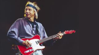Mark Knopfler of Dire Straits performs on stage in Birmingham, 1991. He is playing a Schecter guitar.