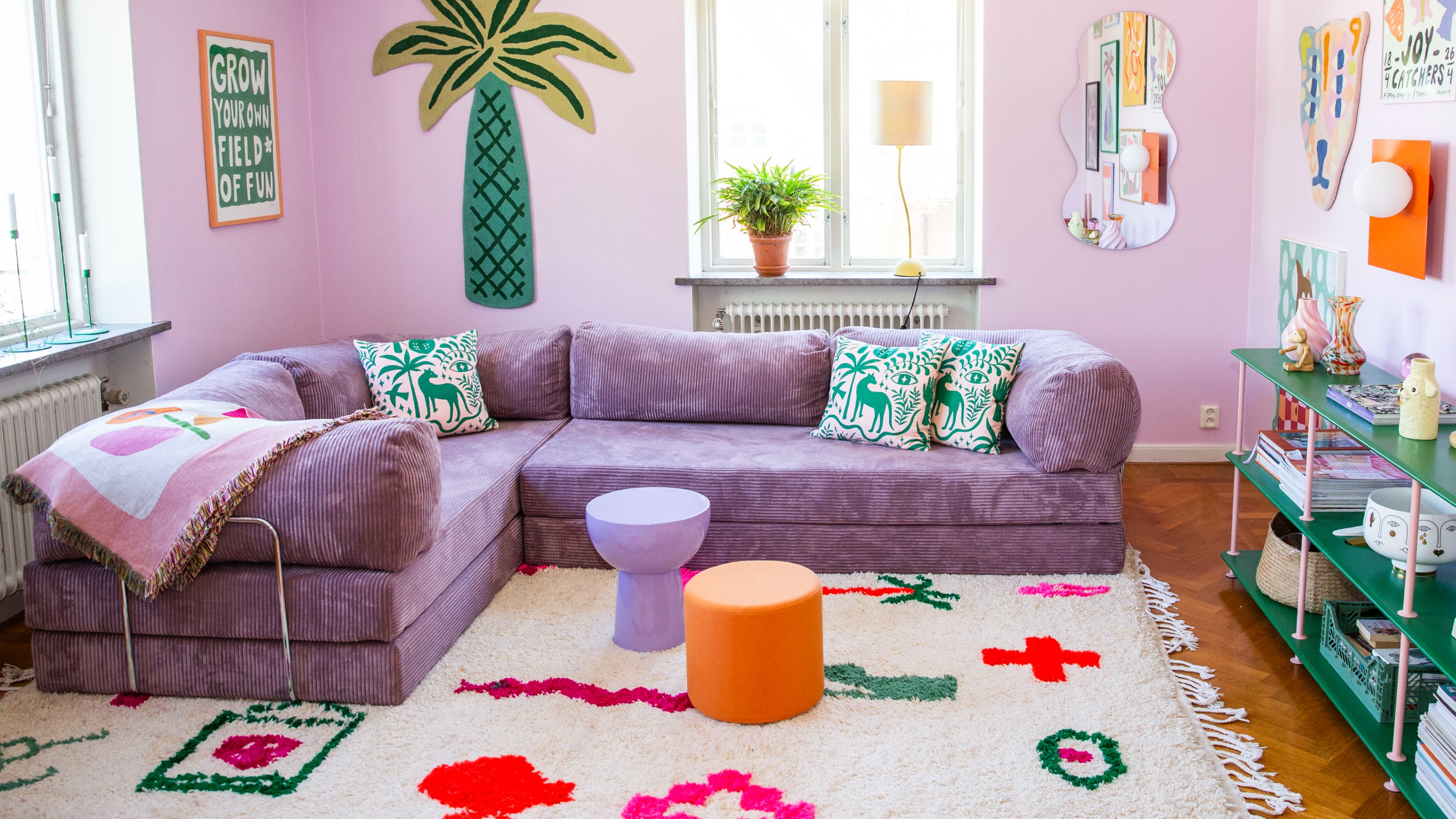 An extended version of the Teddy sofa by OMHU in Purple in a living room with tonal walls, patterned soft furnishings and prints hung on the walls