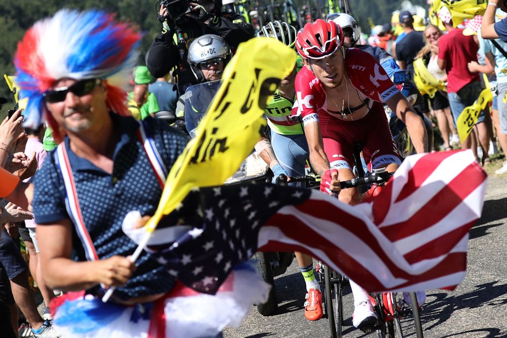 A fan's flag frames Ilnur Zakarin during stage 15