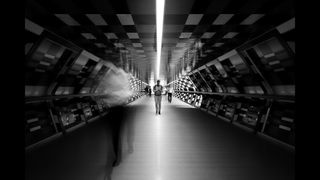 Long exposure of people walking through tunnel with sharp person in the center of the frame